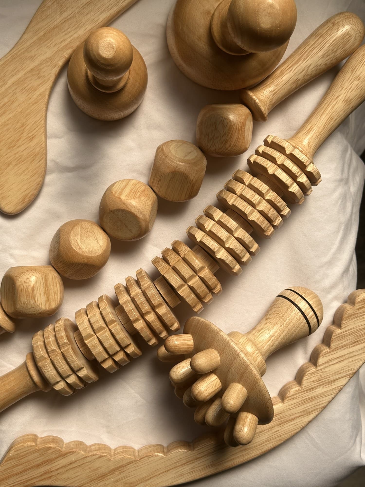 Instruments de madérothérapie en bois posés sur un linge clair